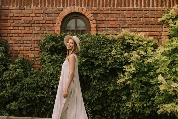 Young woman with hat walking in the resort garden