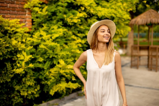 Young woman with hat walking in the resort garden