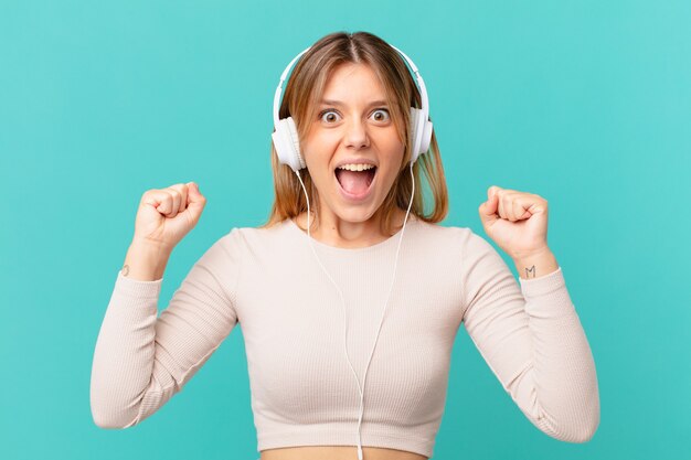 Photo young woman with headphones shouting aggressively with an angry expression