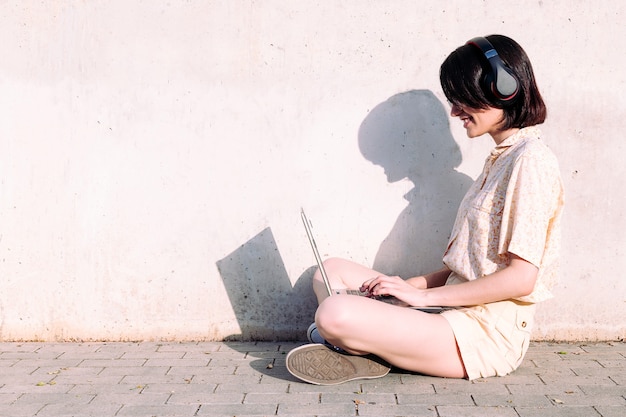 Young woman with headphones working with a laptop