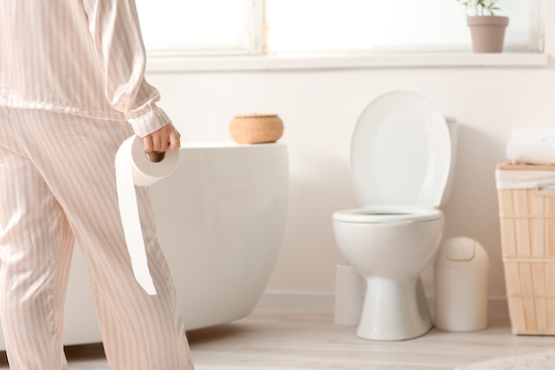 Young woman with hemorrhoids visiting bathroom