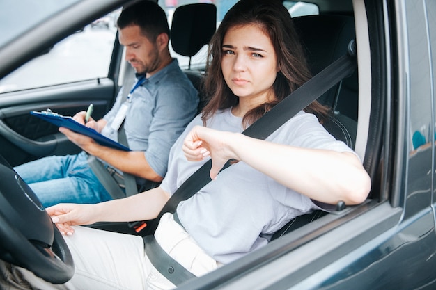 Young woman with her auto instructor in a car