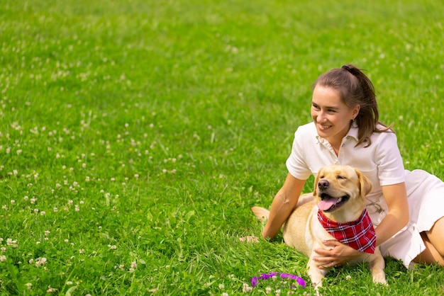 Young woman with her cute yellow labrador outside Lovely pet animal love concept