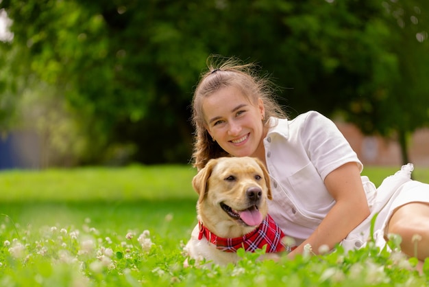 Young woman with her cute yellow labrador outside Lovely pet animal love concept