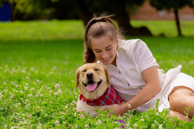 Young woman with her cute yellow labrador outside Lovely pet animal love concept