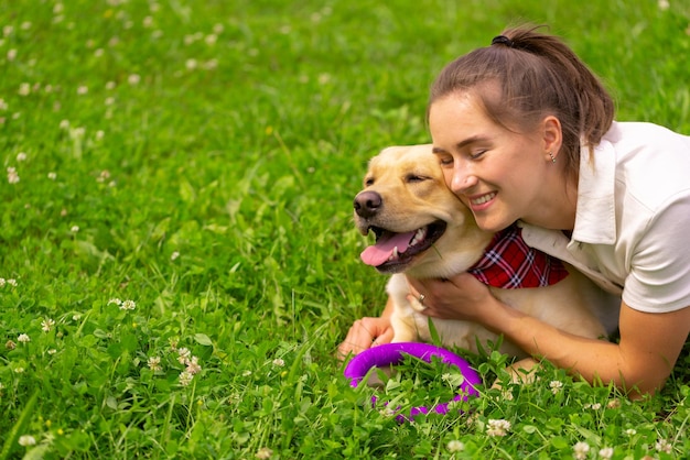 Young woman with her cute yellow labrador outside Lovely pet animal love concept