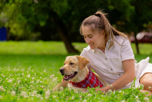 Young woman with her cute yellow labrador outside Lovely pet animal love concept