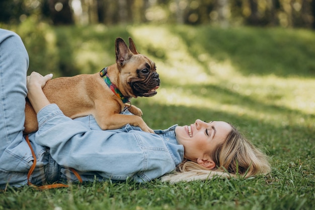 Young woman with her pet french bulldog in park