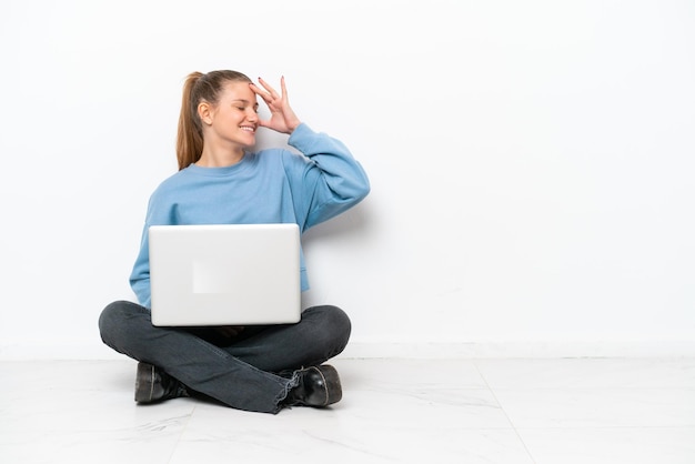 Young woman with a laptop sitting on the floor has realized something and intending the solution