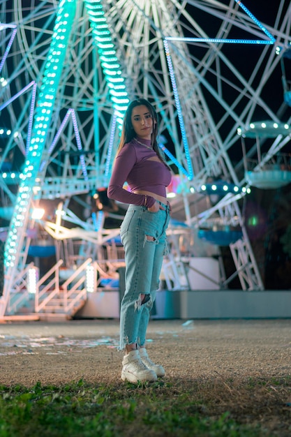 Young woman with the lights of a Ferris wheel in the background