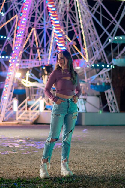 Young woman with the lights of a Ferris wheel in the background