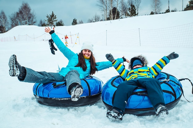 Young woman with little kid on snow tubes