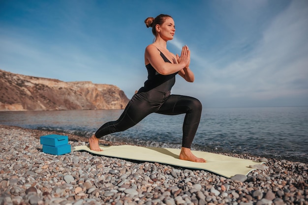 Young woman with long hair fitness instructor in black sportswear leggings and tops stretching