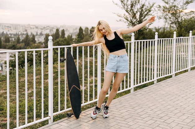 Young woman with a longboard, outdoors