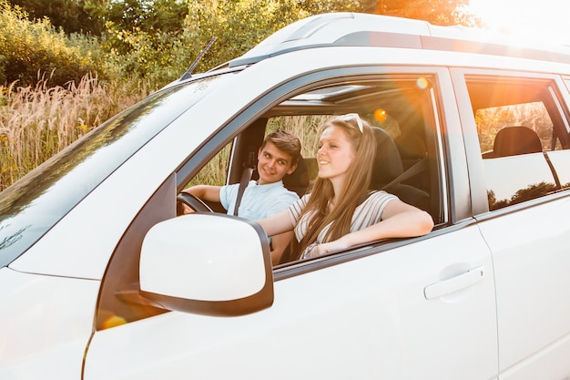 Young woman with man in car. summer road trip