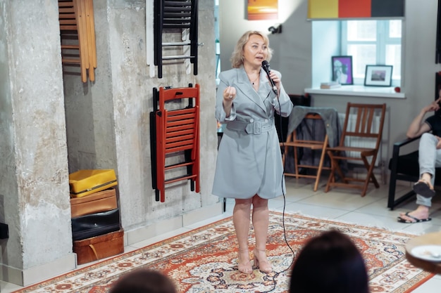 Young woman with a microphone at a public speaking training