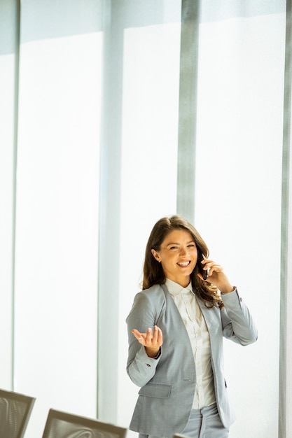 Young woman with mobile phone by the window