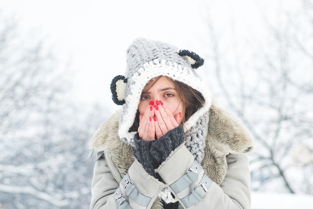 Young woman with nose wiper near winter tree woman with napkin sneezing in the winter snowy park you...