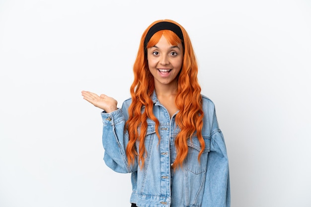 Young woman with orange hair isolated on white background holding copyspace imaginary on the palm to insert an ad