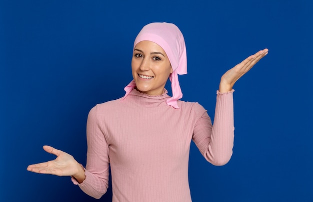 Young woman with pink scarf on the head on a blue