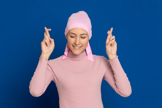 Young woman with pink scarf on the head on a blue