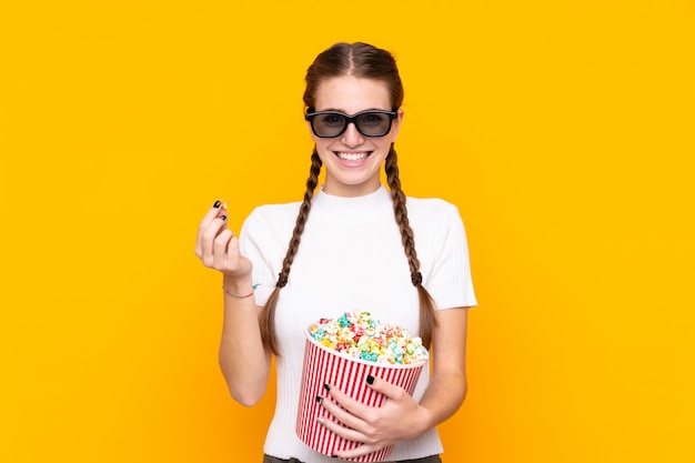 Young woman with popcorns over isolated wall 