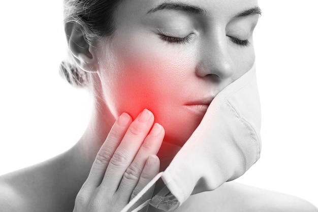 Young woman with prevention mask and skin irritation on white background. Maskne - acne breakouts from wearing a face mask.