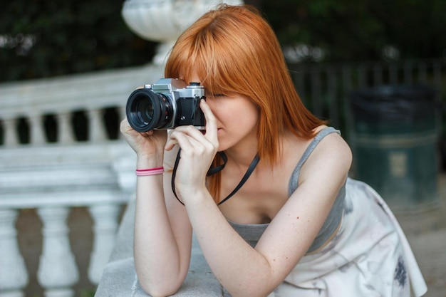 Young woman with retro camera in the park