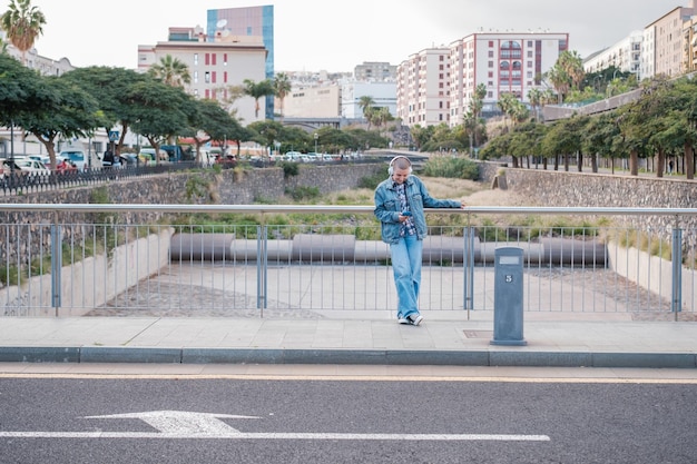 Young woman with short hair on a bridge checking her smartphone Concept Lifestyle street life urban style