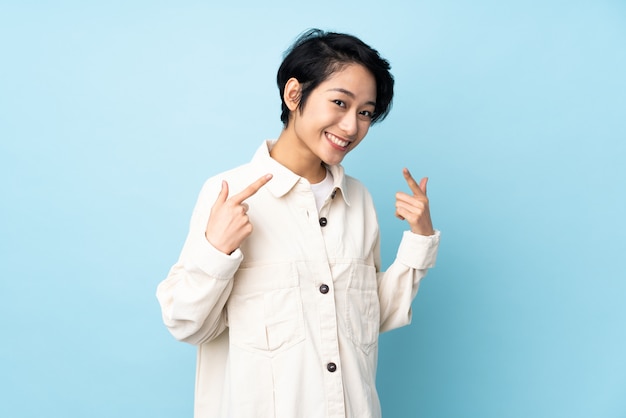 Young woman with short hair over giving a thumbs up gesture