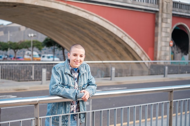 Young woman with short hair leaning on the railing of a bridge outdoors Concept lifestyle empowerment feminism