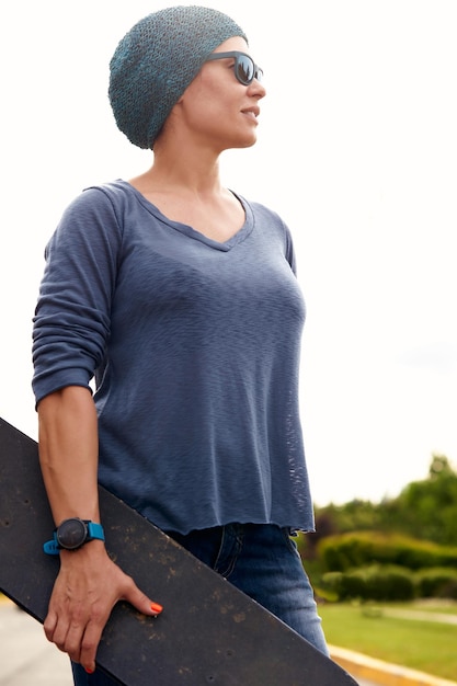 Young woman with a skateboard on the street