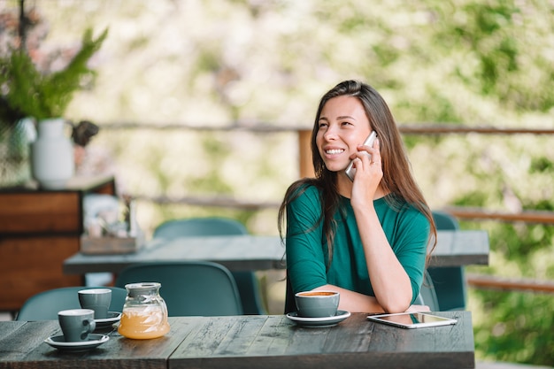 Young woman with smart phone while sitting alone in coffee shop during free time