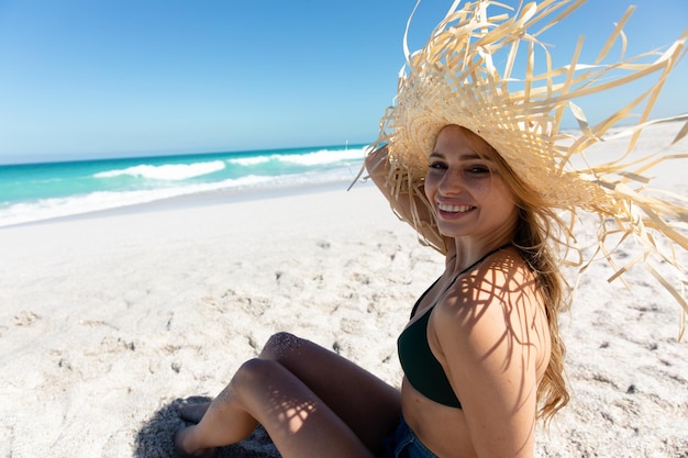 Young woman with straw hat at the beach