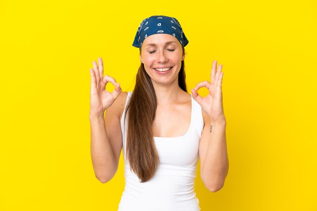 Young woman with strawberry milkshake over isolated blue background smiling and showing victory sign