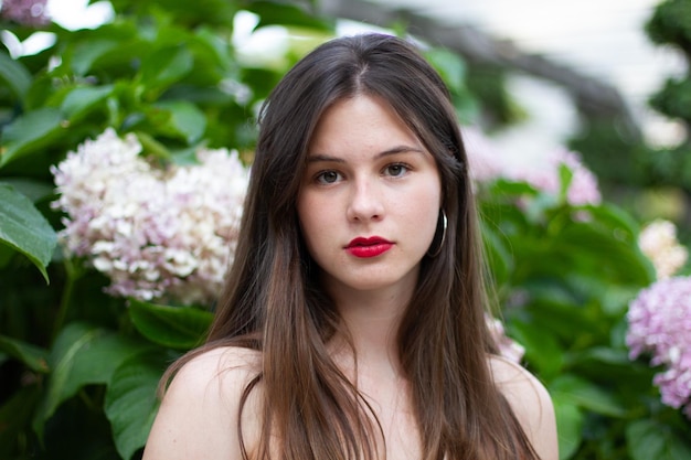 Young woman with stylish clothes posing in a paradisiacal park