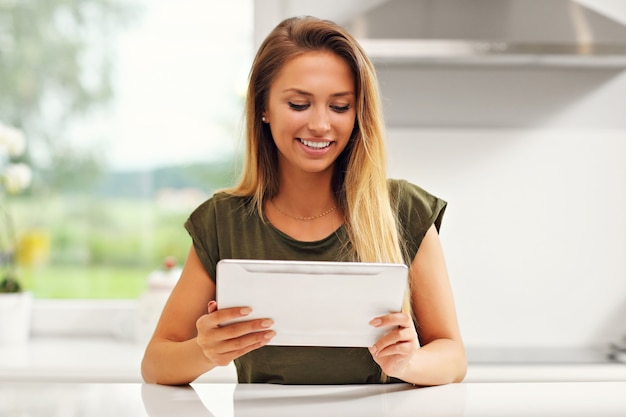 young woman with tablet in kitchen