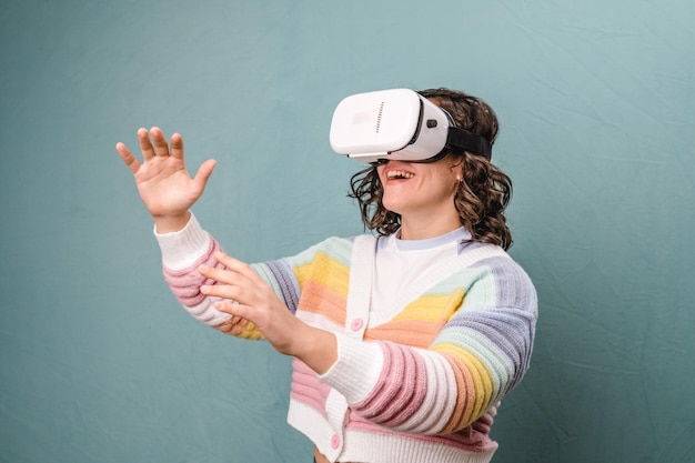 Young woman with virtual reality goggles excitedly on a blue background