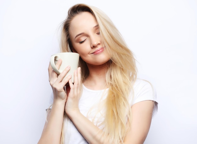 Young woman with white cup tea or coffee over white background