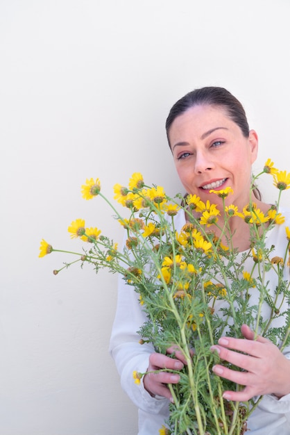 Young woman with wildflowers on white