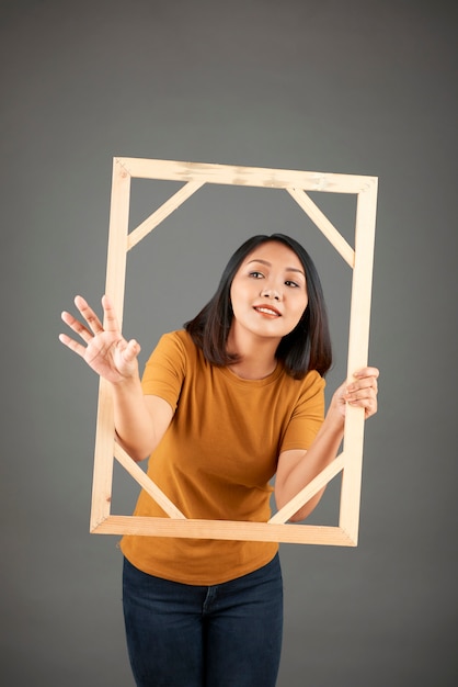 Young woman with wooden picture frame