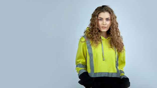 A young woman in a work uniform on a gray background