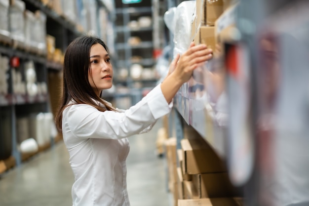 Young woman worker checking inventory in the warehouse store