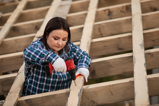 The young woman worker make frame of the roof