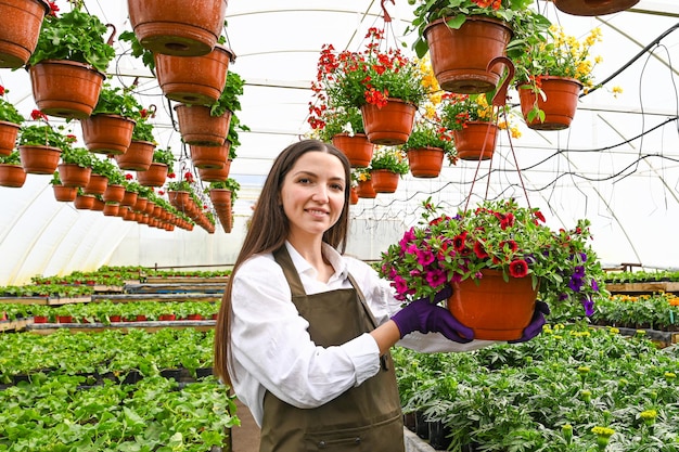 Young woman working in beautiful colorful flower garden greenhouse My job is my passion