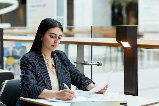 Young Woman Working at Cafe in Office Lounge