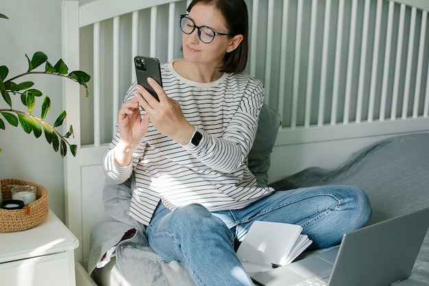 Young woman working from home office Freelancer using laptop phone and the Internet