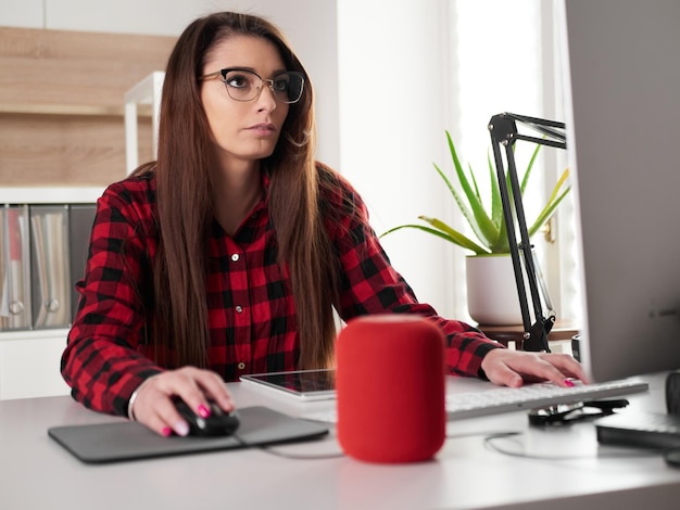 Young woman working at home on desktop pc and digital tablet