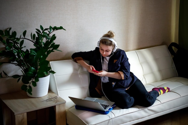 Young woman working on laptop computer while sitting at the living room