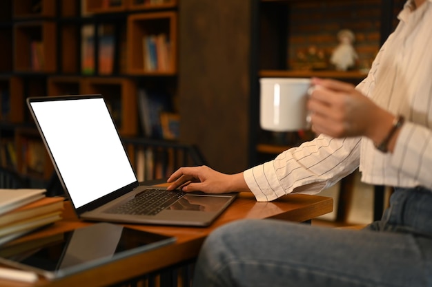 Young woman working online from home surfing internet with laptop computer